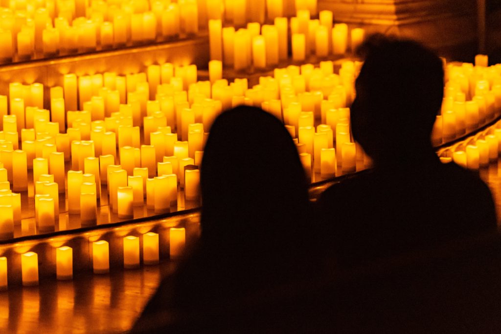 silhouette of a couple in front of hundreds of candles for a candlelight concert