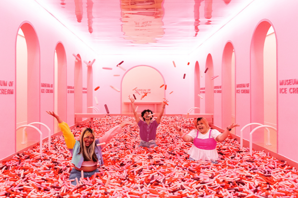 Three people having fun in the sprinkle pool at the Museum Of Ice Cream Singapore