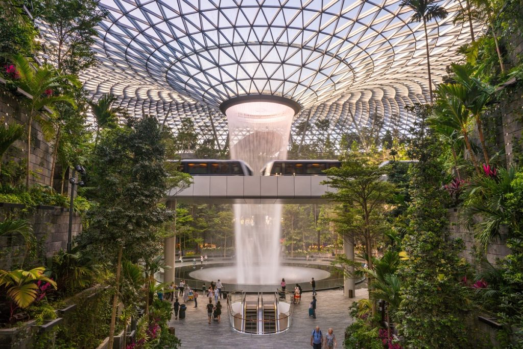The spectacular waterfall of Singapore Changi Airport, with a shuttle passing in front of it.