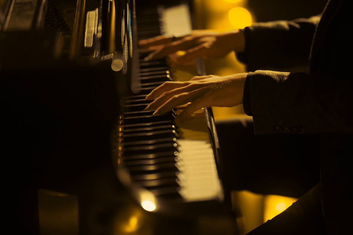 A close up of hands playing the piano.