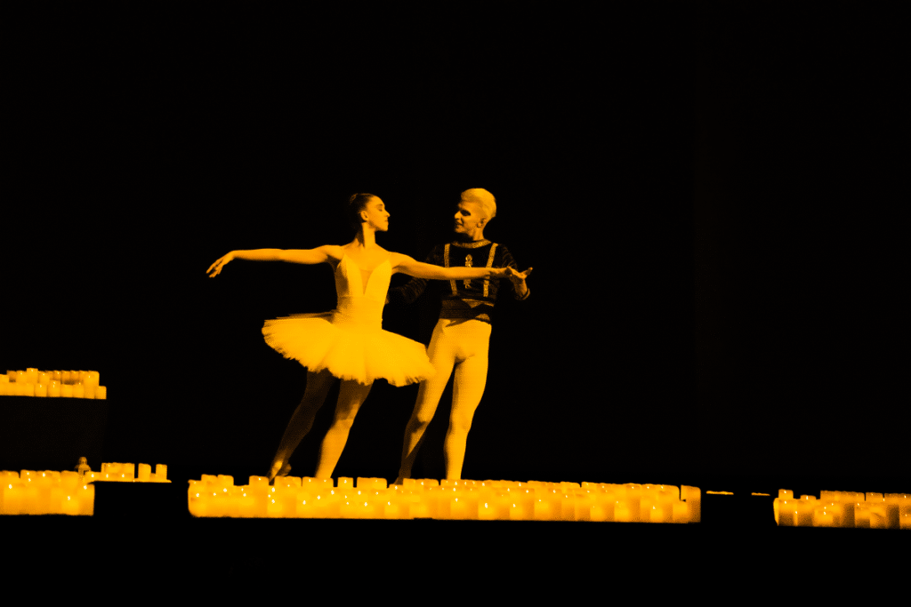 Two ballet dancers on stage illuminated by hundreds of candles