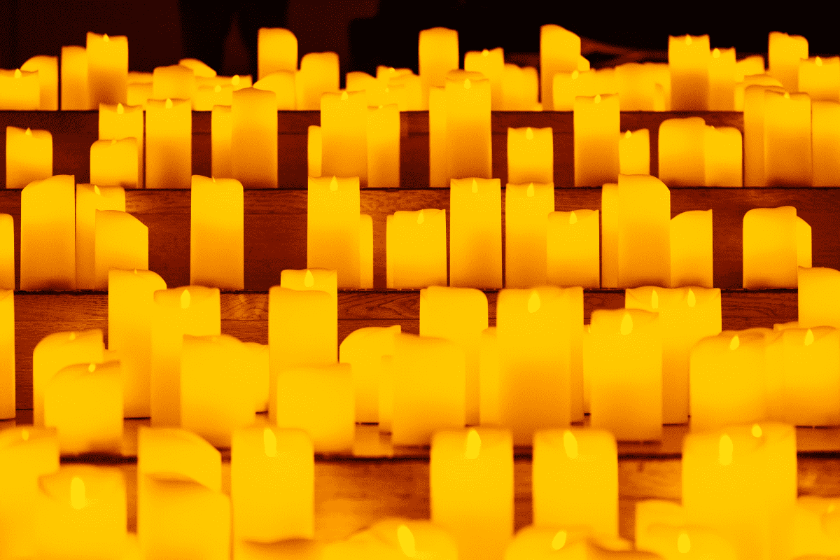 A close up of candles on display on wooden steps.
