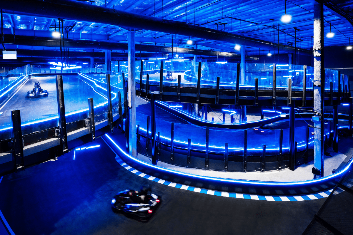 A multi-level go kart circuit in Singapore, illuminated with blue lights.