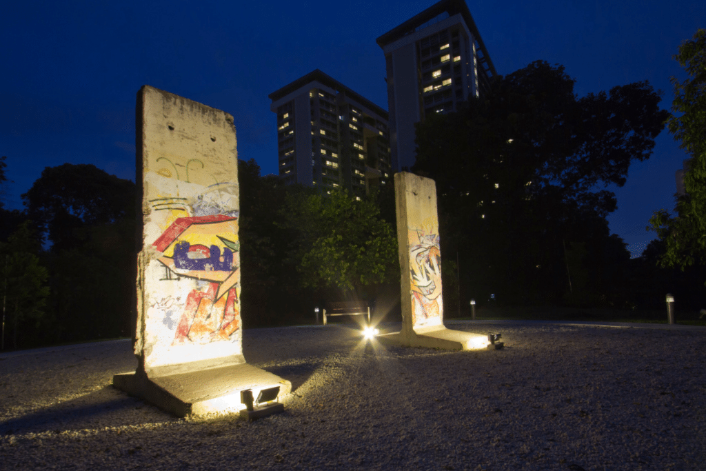 Two slabs of the Berlin Wall are illuminated at night in the gardens of Tembusu College in Singapore