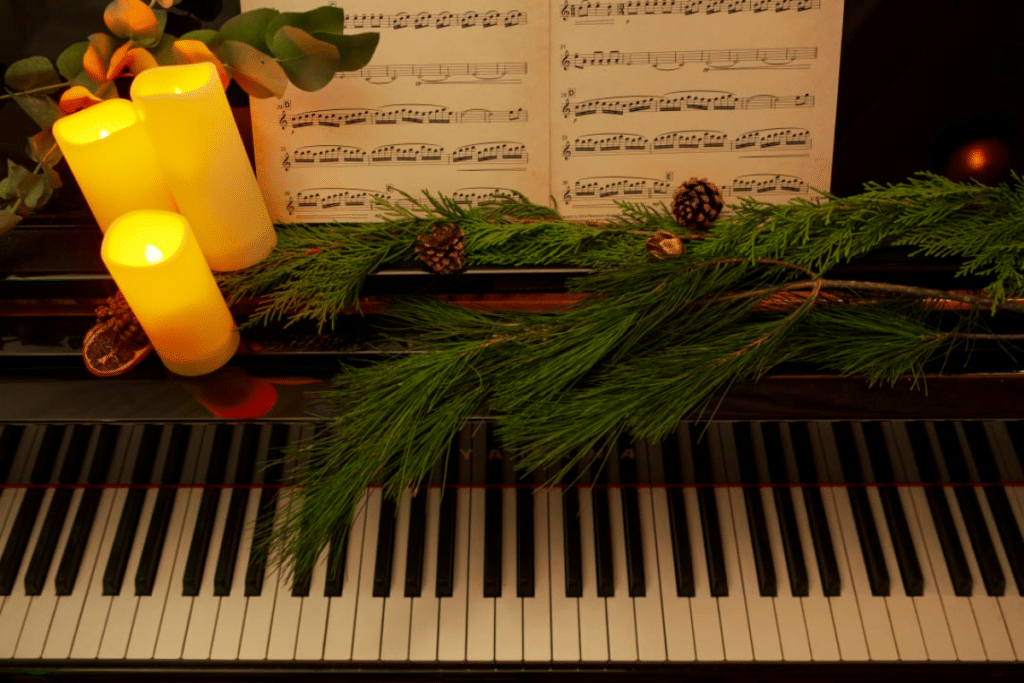 A piano adorned with candles and holly for a Candlelight Christmas concert